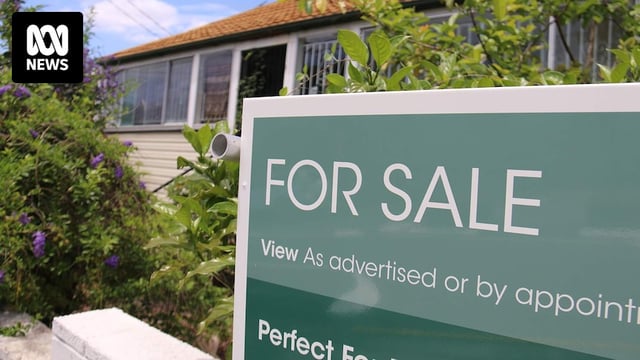 For sale sign on Queenslander-style house that needs renovating in a street in Brisbane.