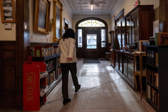 Library clerk Lee Anne Smith walks from Canada into the U.S. at the Haskell Free Library and Opera House, which straddles the U.S.-Canada border in Stanstead, Quebec and in Derby Line, Vermont, U.S., marked by a black line on the floor, in Stanstead, Quebec, Canada January 21, 2025. REUTERS/Carlos Osorio/File Photo