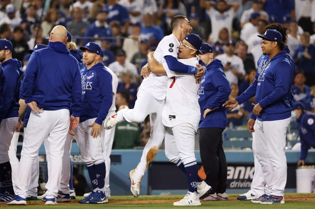 Cody Bellinger #35 and Julio Urias #7 of the Los Angeles Dodgers celebrate their 3 to 1 win over the St. Louis Cardinals during the National League Wild Card Game at Dodger Stadium on October 06, 2021 in Los Angeles, California.