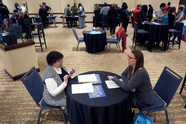 Fired IRS worker Brittany Glenn, right, talks to recruiter Lena Lager during a jobs fair for laid-off federal workers on March 15, 2025, in Kansas City, Mo.