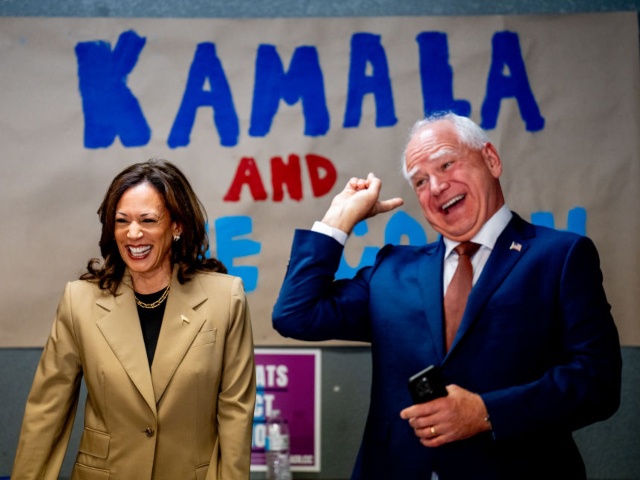 GLENDALE, ARIZONA - AUGUST 9: Democratic presidential candidate, U.S. Vice President Kamala Harris and Democratic vice presidential candidate Minnesota Governor Tim Walz laugh after taking a selfie in front of a sign that reads "Kamala and The Coach" during stop at a campaign office on August 9, 2024 in Glendale, Arizona. Kamala Harris and her newly selected running mate Tim Walz are campaigning across the country this week. (Photo by Andrew Harnik/Getty Images)