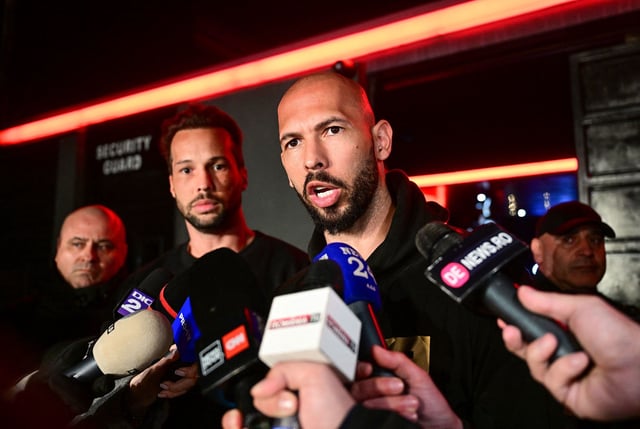 Andrew Tate, right and his brother Tristan, center, speak to the media as they arrive in Bucharest, Romania back from US, on Saturday.