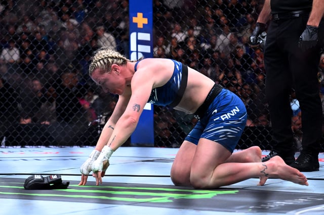 Molly McCann places her gloves down in the middle of the ring after defeat to Istela Nunes (not pictured) in her final fight after announcing her retirement during the Women&#39;s Strawweight fight between Molly McCann and Alexia Thainara.