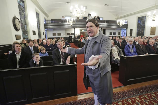 FILE - Virginia Gov-elect, Terry McAuliffe, seated center, listens as historical interpreter, Michael Wells, center, re-enacts the speech of Patrick Henry in St. John's church on church Hill in Richmond, Va., Friday, Jan. 10, 2014. McAuliffe is due to be inaugurated as the 72nd Governor of Virginia. (AP Photo/Steve Helber, File)