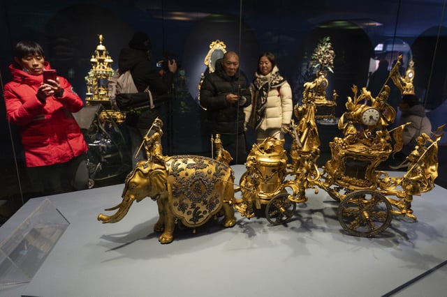 Visitors look at elaborate antique clocks displayed on the sprawling compound of the Forbidden City also known as the Palace Museum in Beijing, Friday, Feb. 21, 2025. (AP Photo/Ng Han Guan)