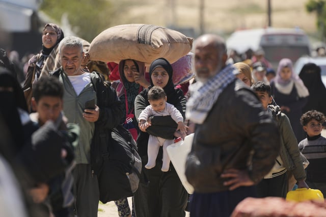 Displaced Palestinians, who flee from Rafah amidst ongoing Israeli military operations following Israel's renewed offensive in the Gaza Strip, arrive in Khan Younis, Gaza, on Sunday, March 23, 2025. (AP Photo/Abdel Kareem Hana)