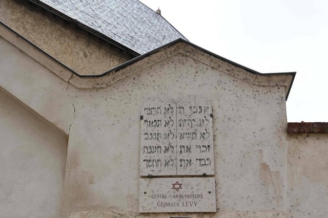 Une plaque d'inscription est placée sur la porte d'entrée d'une synagogue à Orléans, dans le centre de la France, le 23 mars 2025.