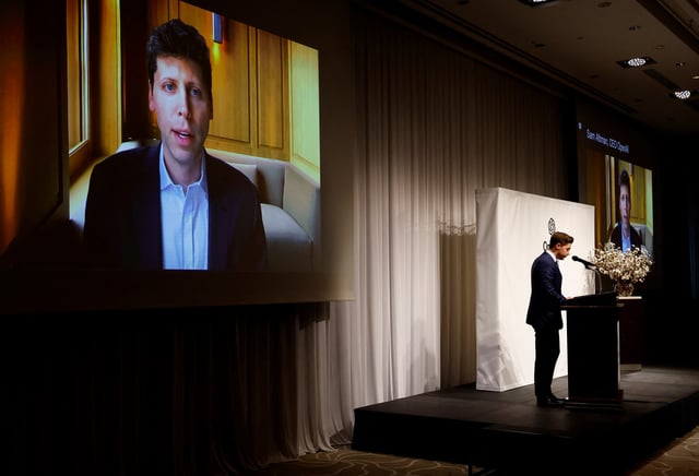OpenAI CEO Sam Altman’s video message is projected next to Chief Operating Officer Brad Lightcap at a press conference about the opening of its first Asia office in Tokyo, Japan April 15, 2024. REUTERS/Kim Kyung-Hoon/File Photo