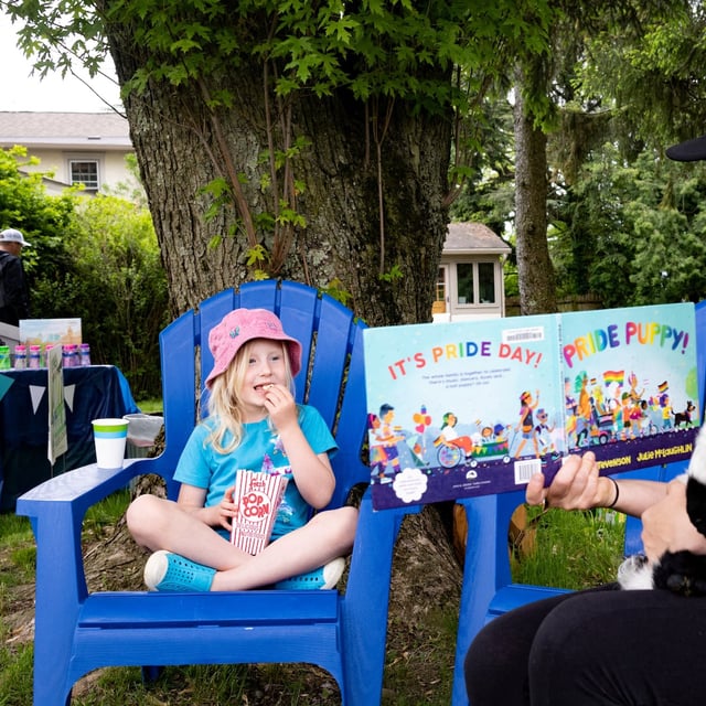(L-R) Masie Bateman, 6, listens as her mother Becca Bateman, 40, reads "Pride Puppy" at a campaign event for Central Bucks School Director Karen Smith who is running for re-election at her home in Chalfont, Pennsylvania, U.S., May 13, 2023. REUTERS/Hannah Beier