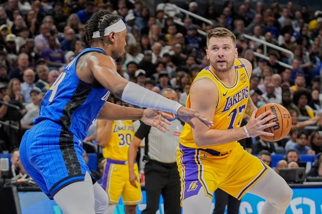 Lakers star Luka Doncic, right, looks to shoot as Orlando Magic center Wendell Carter Jr. defends during the first half on Monday night in Orlando, Fla. (AP Photo/John Raoux)