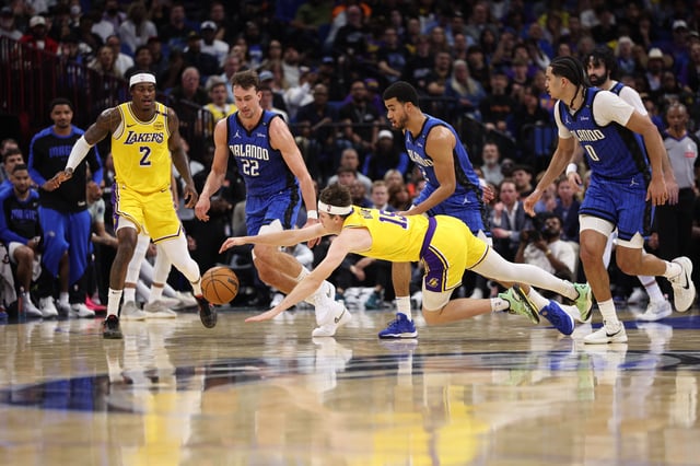 Mar 24, 2025; Orlando, Florida, USA; Los Angeles Lakers guard Austin Reaves (15) scrambles from loose ball against the Orlando Magic in the fourth quarter at Kia Center. Mandatory Credit: Nathan Ray Seebeck-Imagn Images