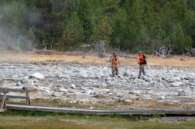 National Park Service officials examine the debris field after a hydrothermal explosion at Black Diamond Pool in Biscuit Basin that launched debris over 600 feet in the air on July 26, 2024, in Yellowstone National Park, Wyo.
