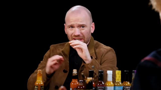 Sean Evans watches Conan O'Brien drink the last hot sauce on "Hot Ones" (Credit: First We Feast/YouTube)