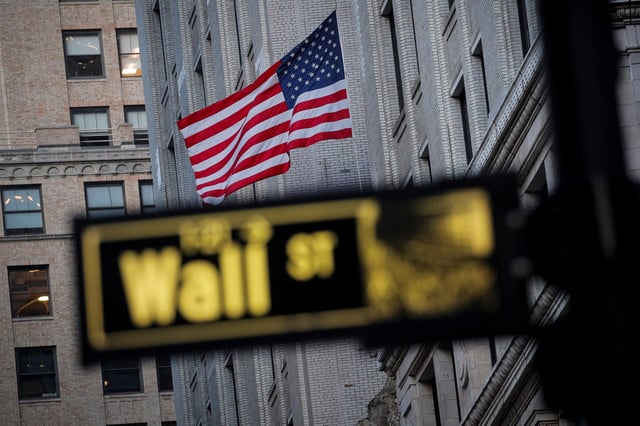 The U.S. flag is seen on a building on Wall St. in the financial district in New York, U.S., November 24, 2020. REUTERS/Brendan McDermid/File Photo