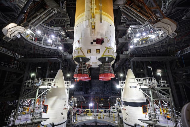 Teams integrate the Space Launch System core stage with the solid rocket boosters for the Artemis II moon mission inside Kennedy Space Center&#39;s Vehicle Assembly Building on Sunday, March 23, 2025. (NASA/Frank Michaux)