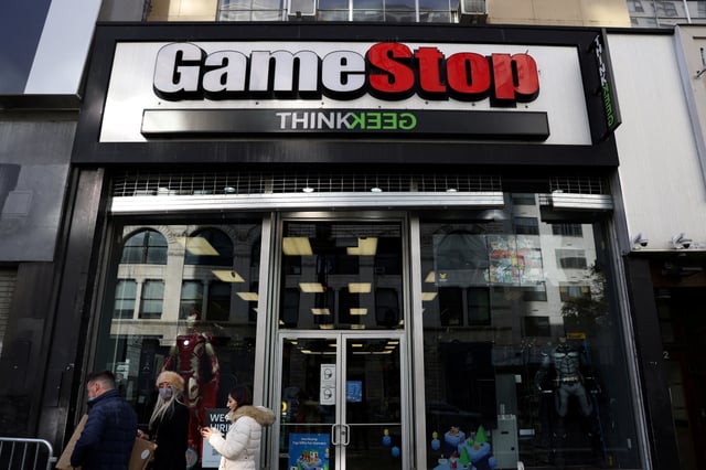 People walk by a GameStop in Manhattan, New York, U.S., December 7, 2021. REUTERS/Andrew Kelly/File Photo