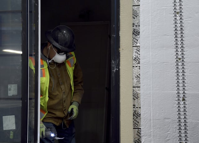 A worker constructs the window of a modular home at the Fading West factory in Buena Vista, Colo., on Feb. 19, 2025. (AP Photo/Thomas Peipert)