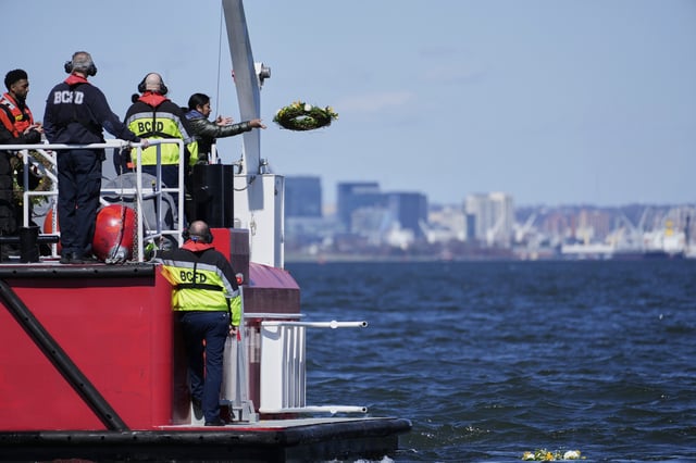 A family member of one of the workers who died during the collapse of the Francis Scott Key Bridge in Baltimore tosses a wreath into the Chesapeake Bay in observance of the one-year anniversary of the disaster, Tuesday, March 25, 2025. (AP Photo/Stephanie Scarbrough)