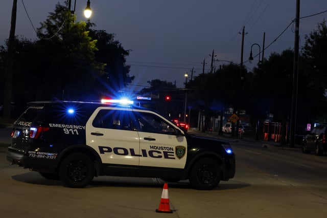 A general view of a Houston Police Department vehicle with their lights flashing to block off a closed street from traffic, Sunday, June 19, 2022, in Houston. This car is not at the scene of the alleged attempted stabbing.