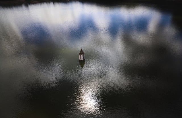 The belfry an 11th century Romanesque church emerges from the Sau reservoir, about 100 km (62 miles) north of Barcelona, in Vilanova de Sau, Spain, on Monday, March 24, 2025. (AP Photo/Emilio Morenatti)