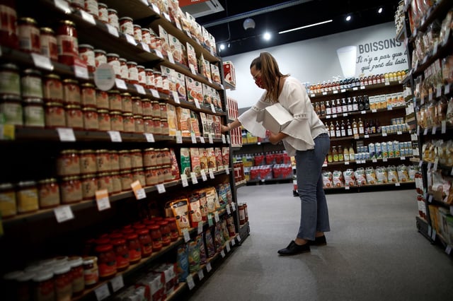 An employee restocks a sales at a grocery store in Bretigny-sur-Orge, near Paris.