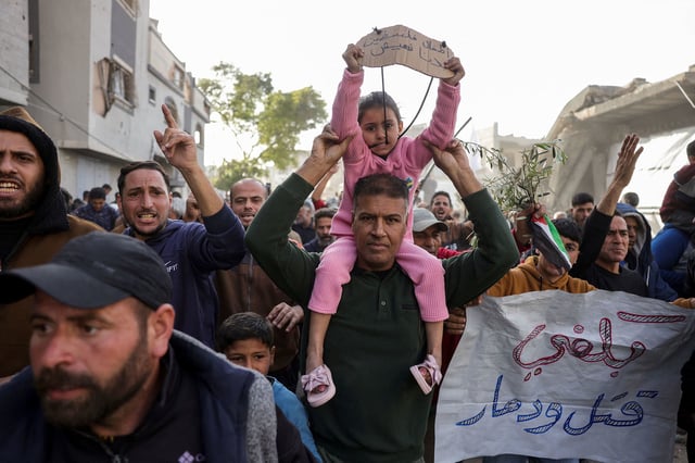Arabic signs reading (left), 'The children of Palestine: We want to live,' and (right), 'Enough killing and destruction,' at a protest in Beit Lahia, in the northern Gaza Strip, on Tuesday.