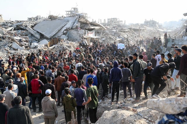 Vor dem in Schutt und Asche gelegten Gaza, hat sich eine stattliche Ansammlung von Menschen eingefunden um gegen den Krieg zu demonstrieren.
