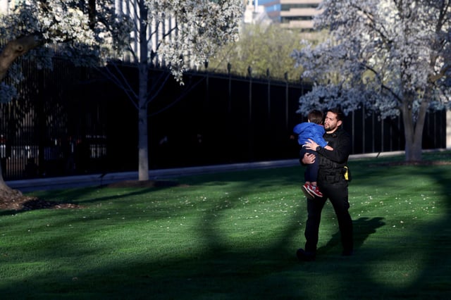 A Secret Service officer carries a child that slipped through the fence of the White House in Washington, D.C., U.S., March 26, 2025.