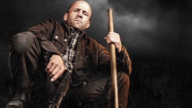 Jason Statham holding a gun and looking downwards in A Working Man.