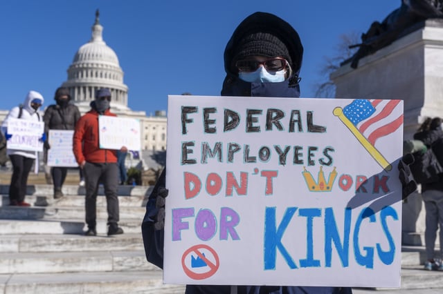 FILE - A federal employee, who asked not to use their name for fears over losing their job, protests with a sign saying "Federal Employees Don't Work for Kings" during the "No Kings Day" protest on Presidents Day , Feb. 17, 2025, near the Capitol in Washington. (AP Photo/Jacquelyn Martin, File)