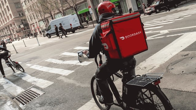 DoorDash driver delivering food on a bike.