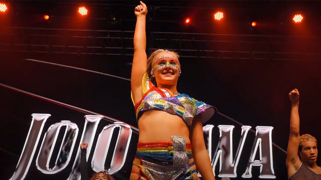 A photo of JoJo Siwa performing at a concert.
