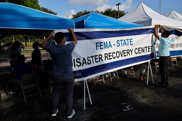 The Federal Emergency Management Agency helps nagmeetn FEMA employees Alec Villeneuve, left, and Thomas Yahn hang a banner on Friday, May 12, 2023, at a FEMA Disaster Recovery Center site located in the parking lot of the Orangebrook Golf &amp; Country Club at 400 Entrada Dr, in Hollywood. A second mobile office can be found at St. George Community Park, 3501 NW 8th Street in Lauderhill and a there is a fixed center at Hortt Park, 1700 SW 14th Court in Fort Lauderdale.
Applicants can visit any site to learn more about FEMA and other disaster assistance programs or ask questions about a specific case. (Amy Beth Bennett/South Florida Sun Sentinel)