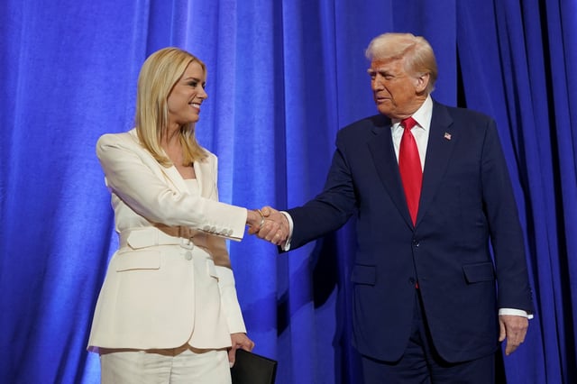 U.S. President Donald Trump and U.S. Attorney General Pam Bondi shake hands during his visit to the Department of Justice to address its workers, in Washington, D.C., U.S., March 14, 2025. REUTERS/Nathan Howard/File Photo