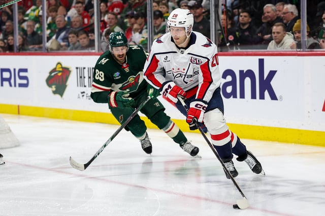 Mar 27, 2025; Saint Paul, Minnesota, USA; Washington Capitals center Lars Eller (20) skates with the puck as Minnesota Wild center Frederick Gaudreau (89) defends during the third period at Xcel Energy Center. Mandatory Credit: Matt Krohn-Imagn Images
