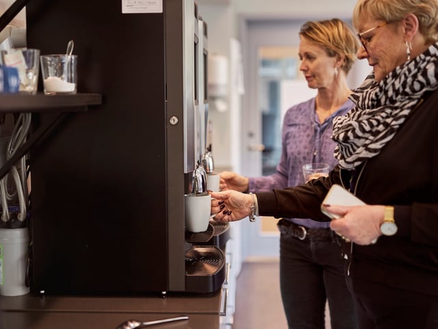 Zwei Frauen stehen am Kaffeeautomaten (Symbolbild).