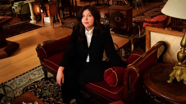 Lucy Dacus sat on a chaise longue