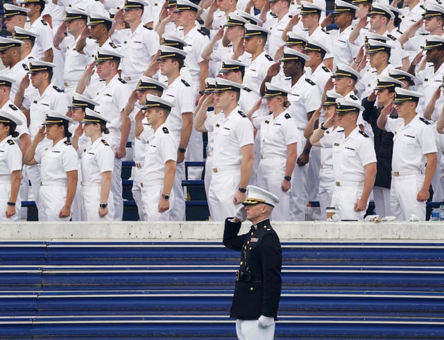 A Marine colonel and midshipmen salute during the national anthem at the U.S. Naval Academy graduation and commissioning ceremony in Annapolis, Maryland, U.S., May 27, 2022. REUTERS/Kevin Lamarque/File Photo