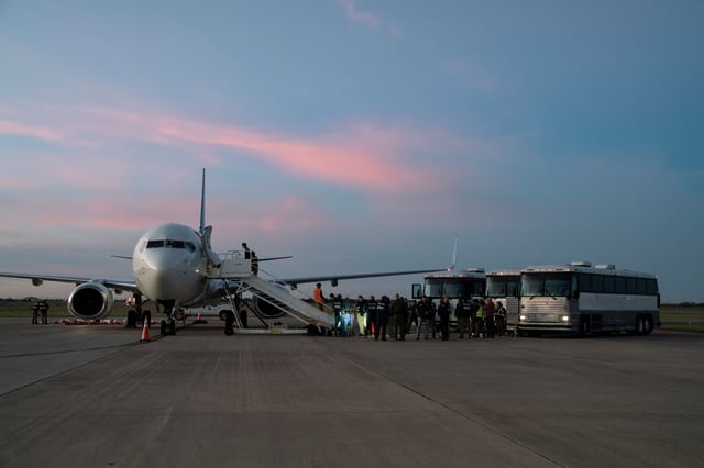 Migrants can be seen boarding a plane during the first deportation flight of undocumented migrants from the U.S. to Venezuela, in Harlingen, Texas, on October 18, 2023.