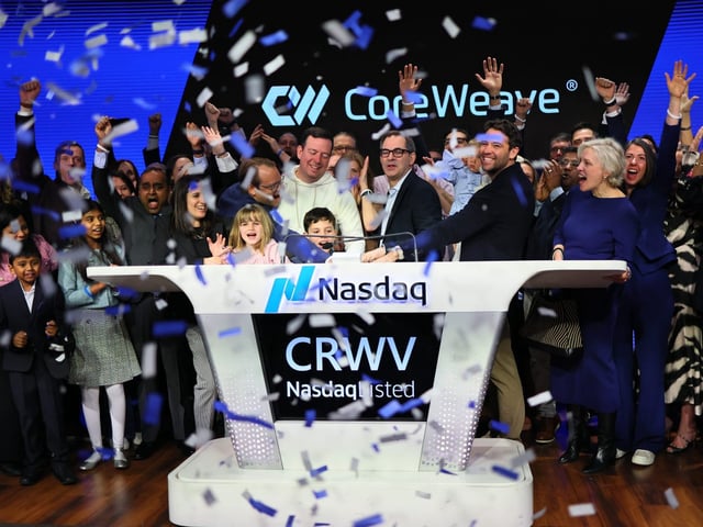 Mike Intrator, Chief Executive Officer and founder of CoreWeave, (C) rings the opening bell surrounded by Executive Leadership and family during the company's Initial Public Offering (IPO) at the Nasdaq headquarters on March 28, 2025 in New York City.