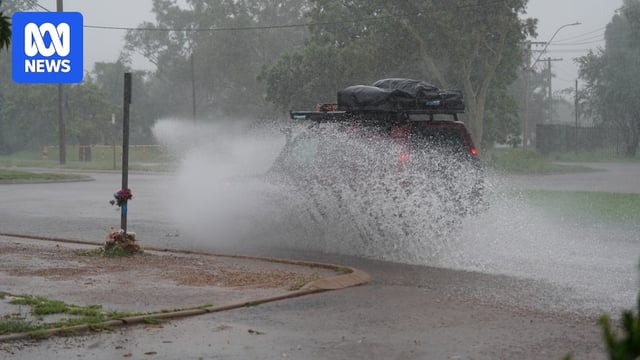 A 4WD splashes water onto a footpath as it drives along a wet road