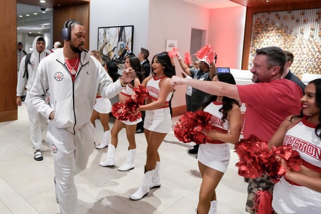 Houston forward J&#39;Wan Roberts, left, gets a fist-bump from a University of Houston cheerleader as the team gets a sendoff from their hotel before a Midwest Regional semifinal basketball game in the NCAA Tournament at Lucas Oil Stadium in Indianapolis, Friday, March 28, 2025.