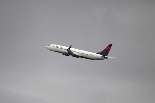 A Delta Airlines Boeing 737-900 passenger jet takes off from Daytona International Airport as viewed from Daytona International Speedway during qualifying for a NASCAR truck series auto race, Friday, Feb. 14, 2025, in Daytona Beach, Fla.