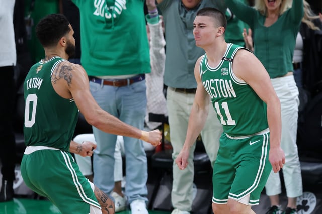BOSTON, MASSACHUSETTS - JUNE 17: Jayson Tatum #0 celebrates with Payton Pritchard #11 of the Boston Celtics after Pritchard&#39;s half court shot at the buzzer against the Dallas Mavericks during the second quarter of Game Five of the 2024 NBA Finals at TD Garden on June 17, 2024 in Boston, Massachusetts.