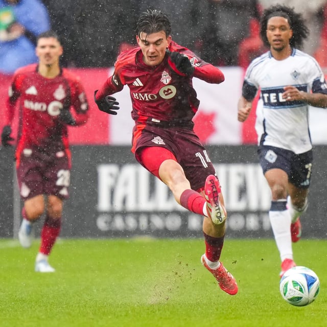 Toronto FC midfielder Alonso Coello (14) runs with the ball as Vancouver Whitecaps forward Jayden Nelson (7) follows during first half MLS soccer action in Toronto on Saturday, March 29, 2025. THE CANADIAN PRESS/Arlyn McAdorey