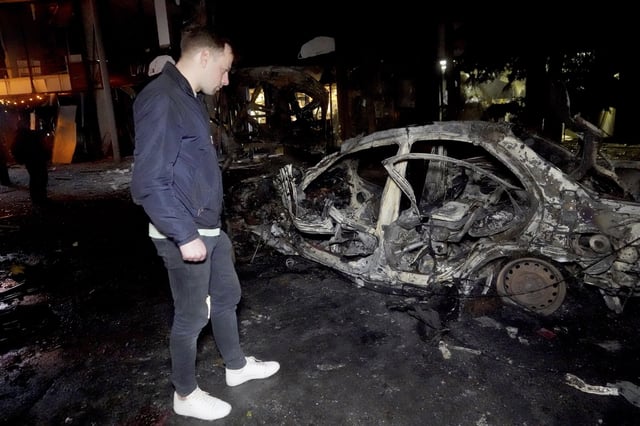 A man looks at a car destroyed in a Russian strike on Kharkiv, Ukraine, Saturday, March 29, 2025. (AP Photo/Andrii Marienko)