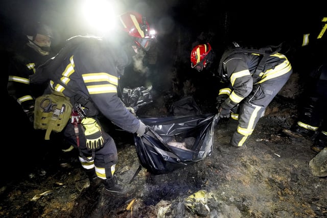Rescue workers collect the body parts of a person killed in a Russian strike on a residential neighborhood of Kharkiv, Ukraine, Saturday, March 29, 2025. (AP Photo/Andrii Marienko)