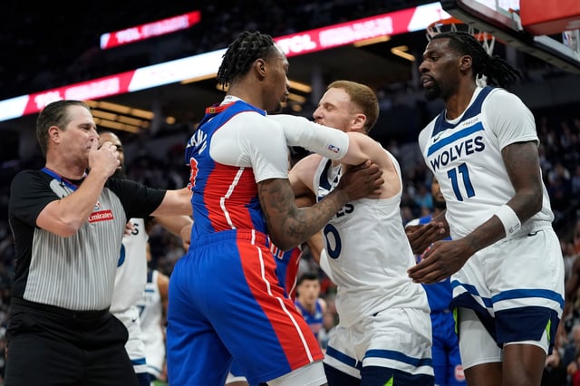 Detroit Pistons forward Ronald Holland II, center left, and Minnesota Timberwolves guard Donte DiVincenzo, center right, fight during the first half of an NBA basketball game, Sunday, March 30, 2025, in Minneapolis. (AP Photo/Abbie Parr)