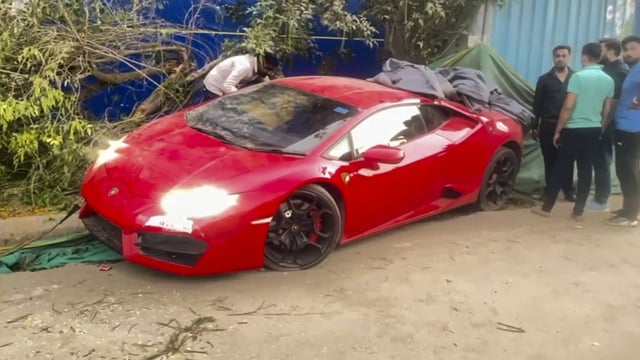 People gather around a Lamborghini car after it allegedly hit people in Noida on Sunday. 