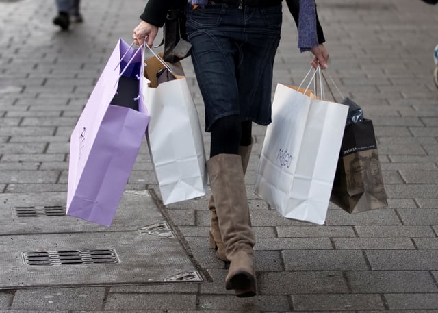 A woman carries shopping bags through the main shopping street in downtown Cologne January 13, 2009. REUTERS/Wolfgang Rattay/File Photo